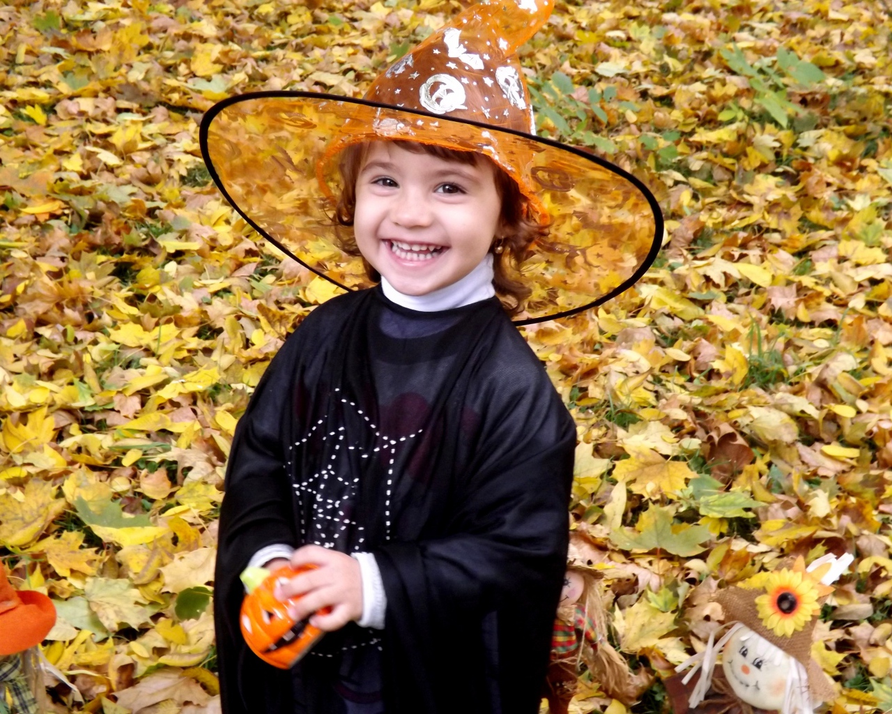 Улыбающаяся девочка в костюме ведьмы на Хэллоуин
