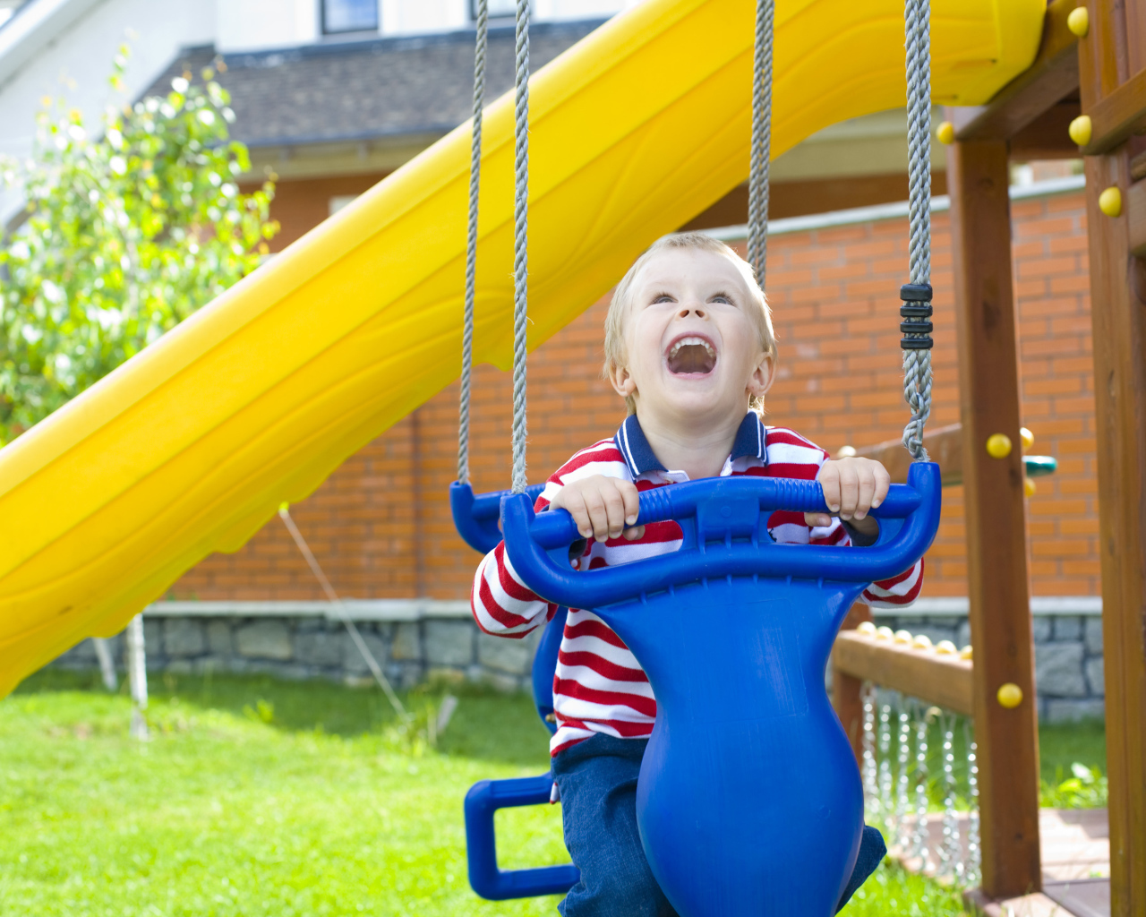 Улыбающийся ребенок на качели 