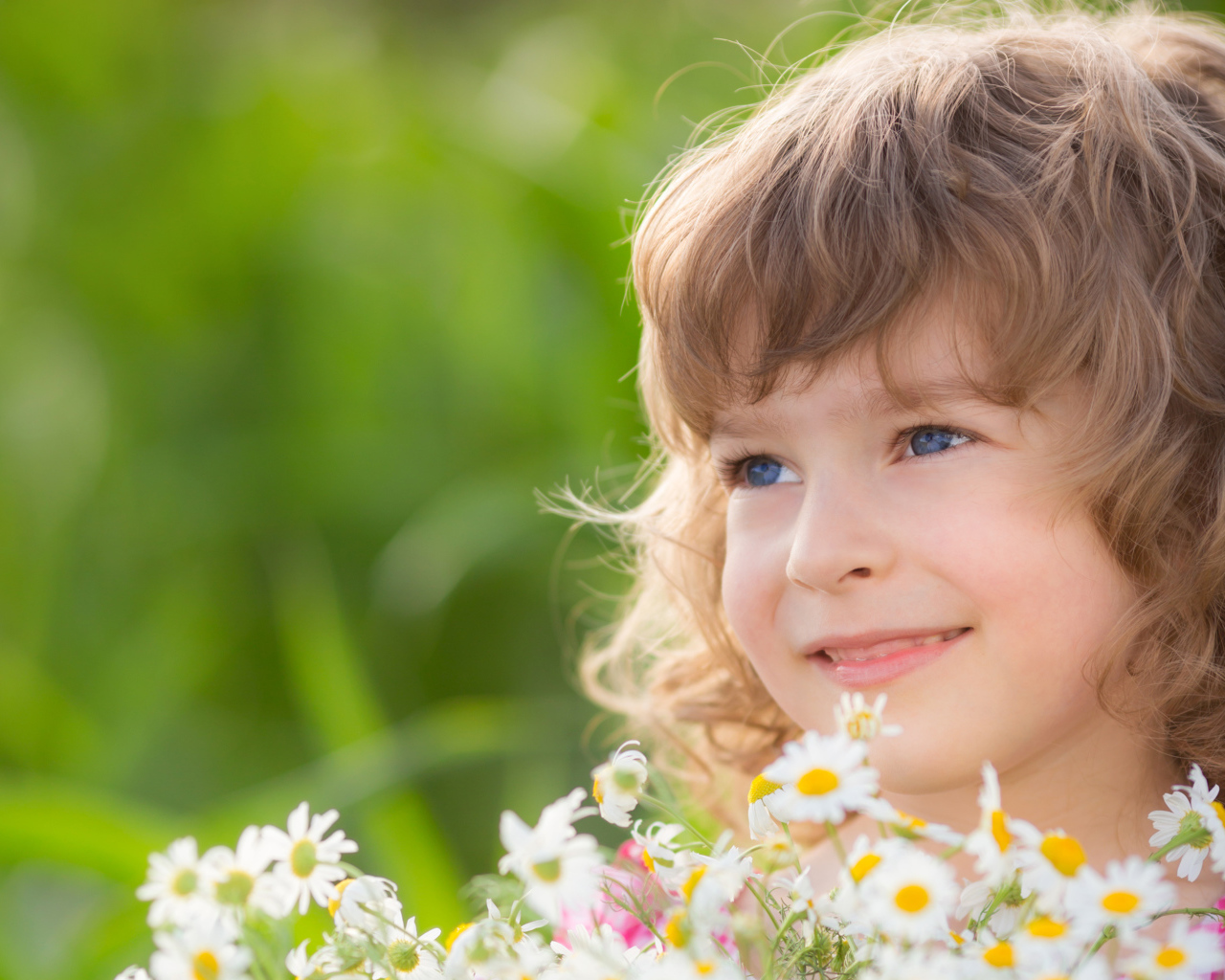 Улыбающаяся девочка с букетом ромашек 