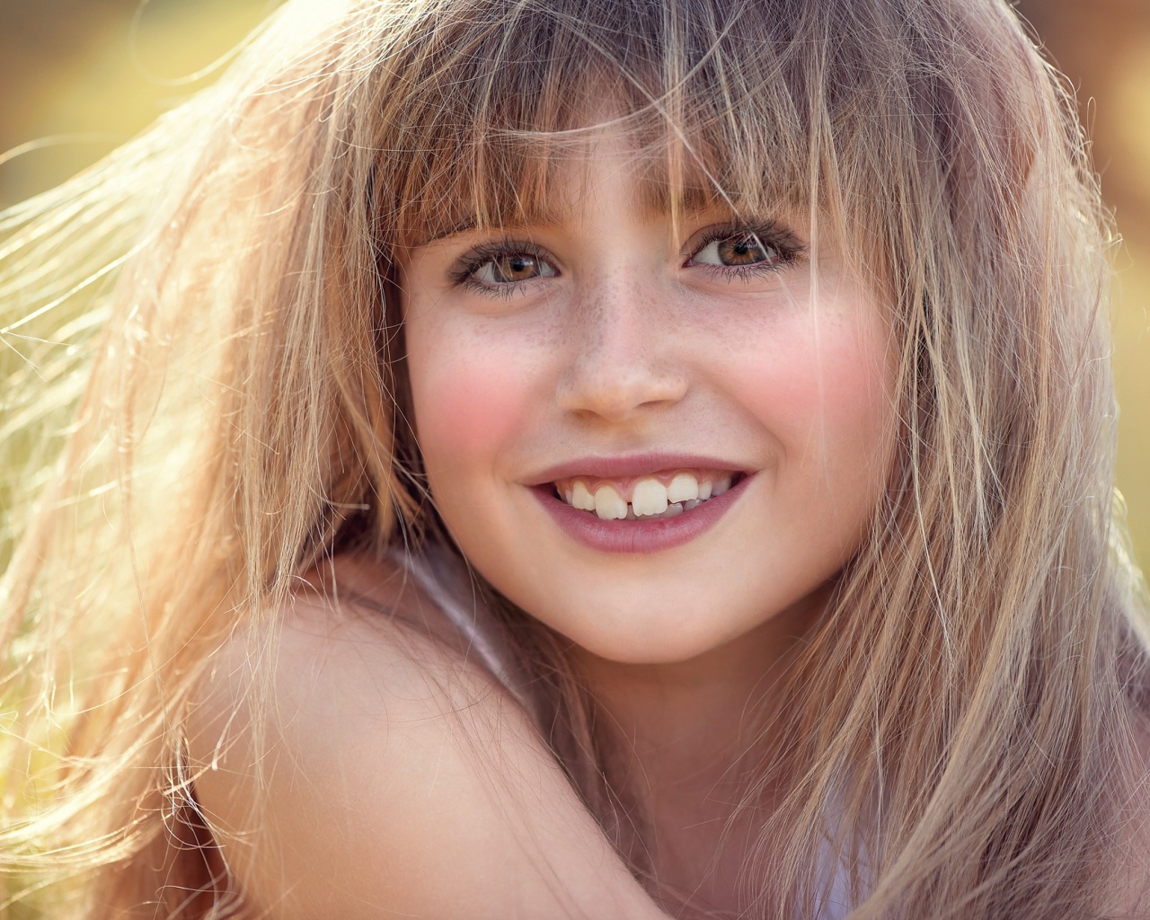 Улыбающаяся девочка с веснушками на лице 