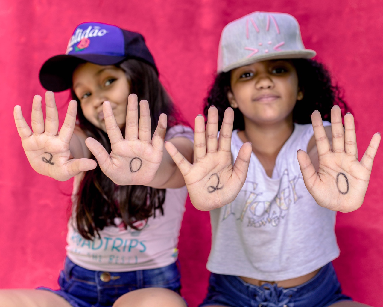 Две маленькие девочка с цифрами на ладонях 