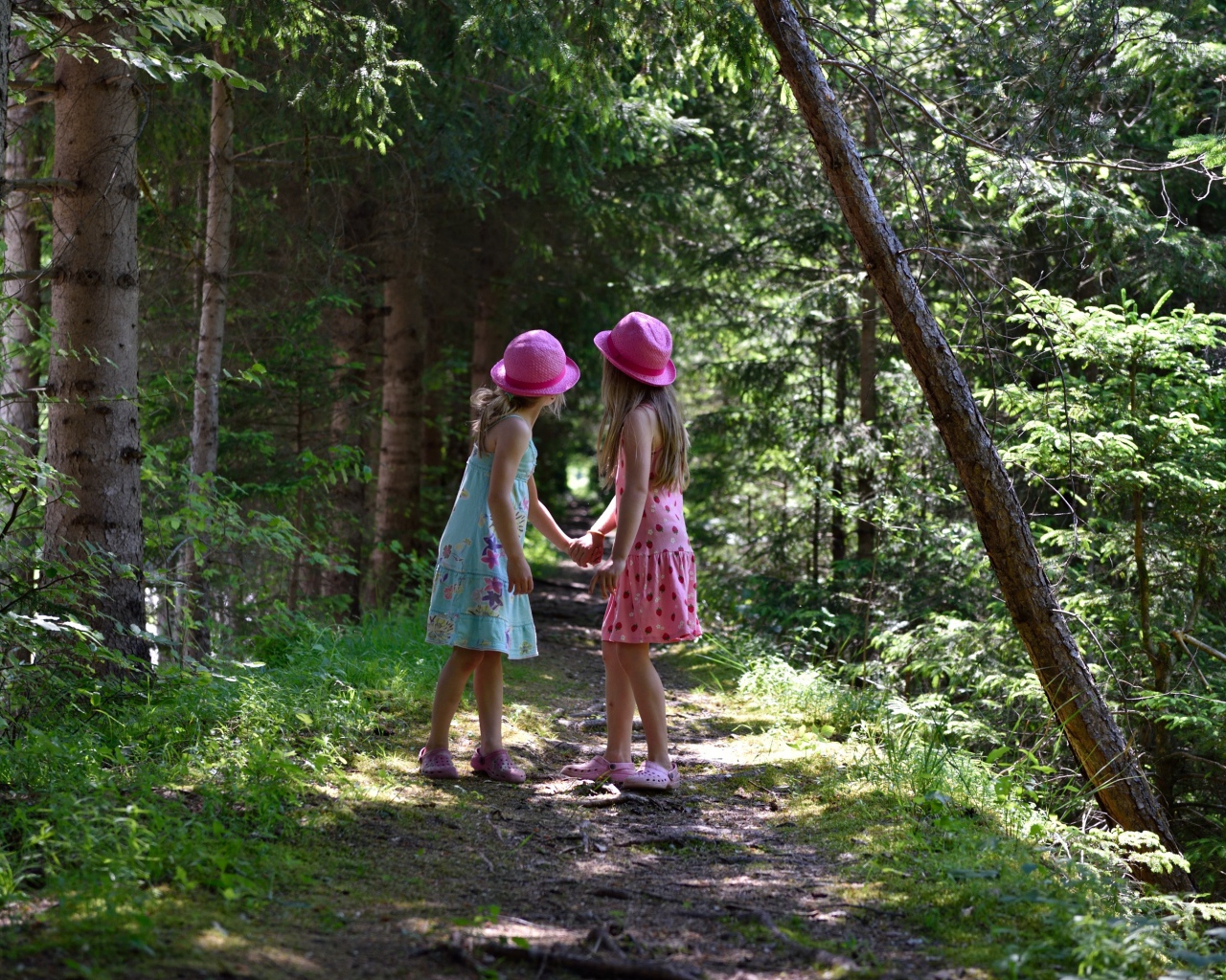 Две маленькие девочки гуляют в лесу