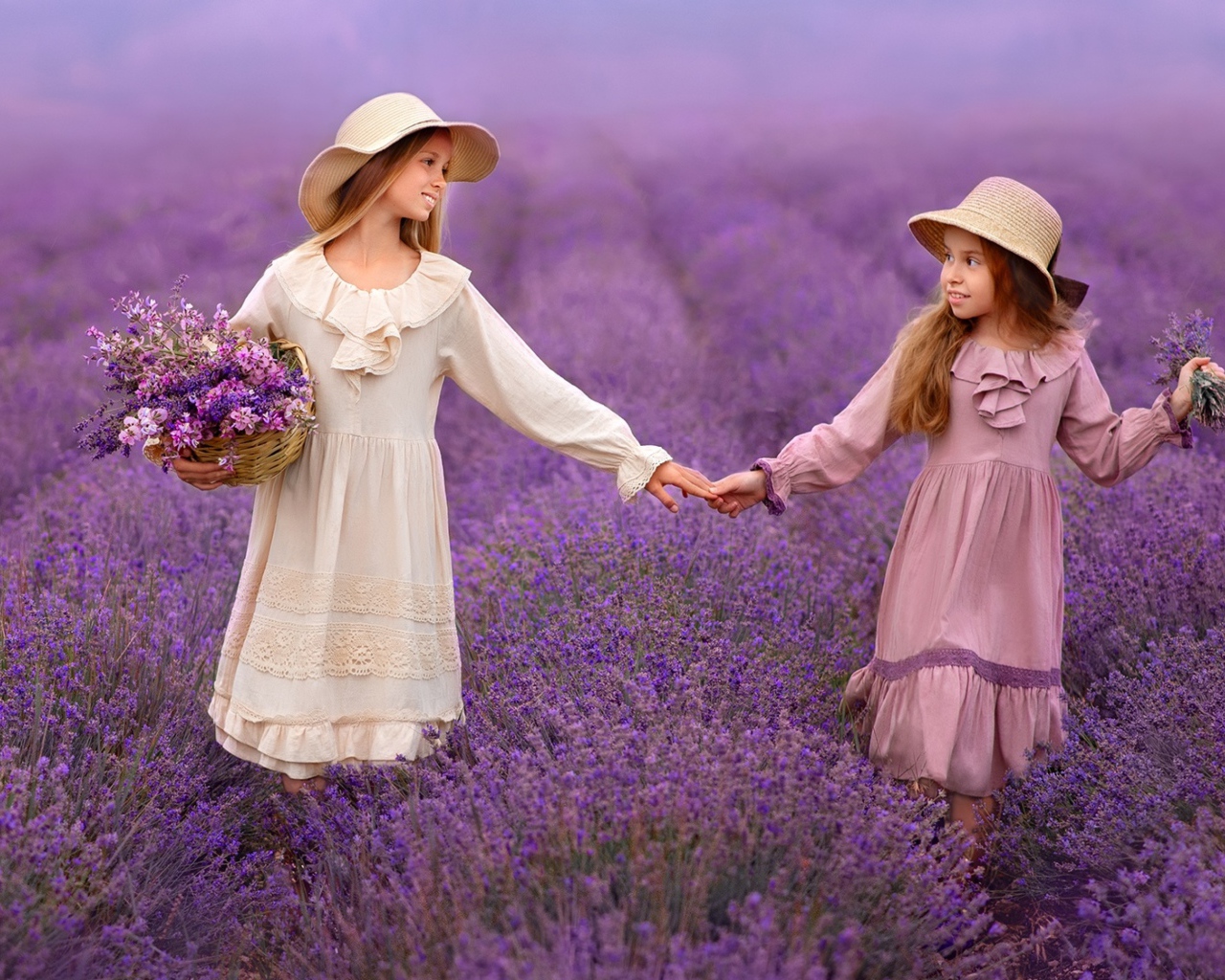 Две маленькие девочки идут по лавандовому полю 