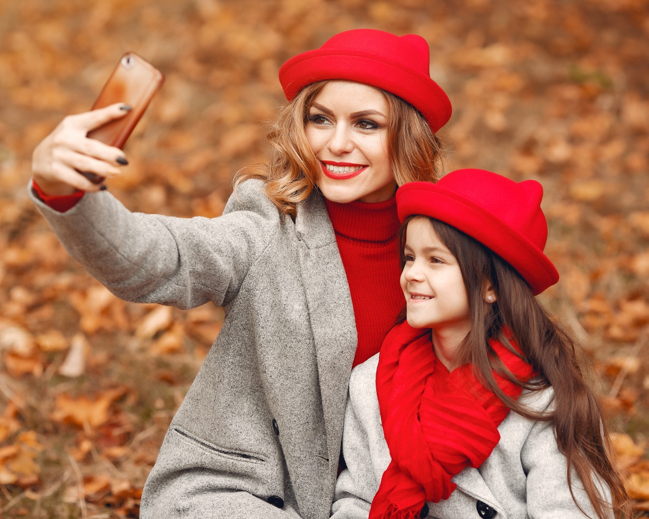 Женщина с маленькой девочкой делают селфи в лесу 