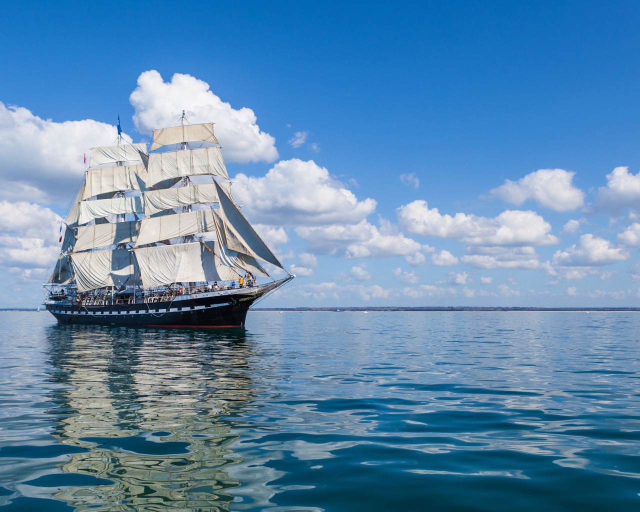 Большой парусный барк в небе над морем с белыми облаками 