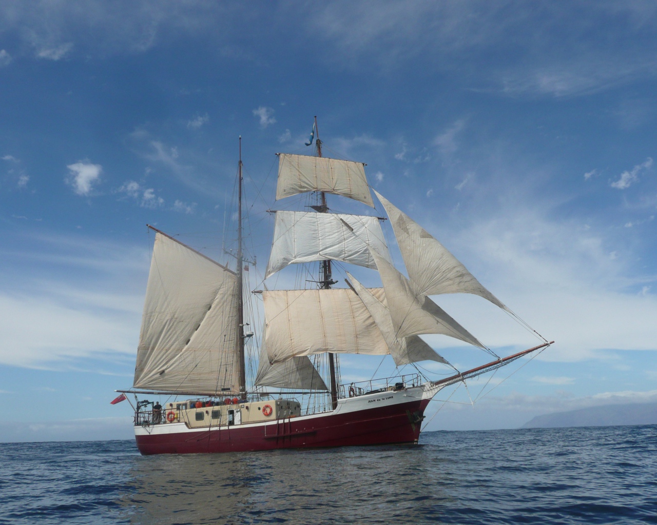 Больше судно с белыми парусами в море 