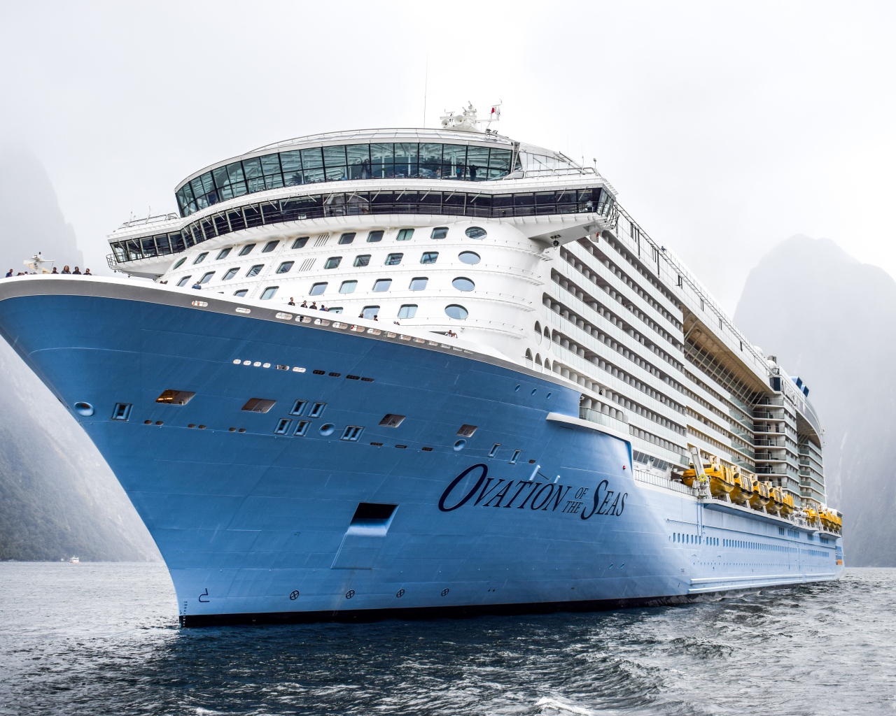 Большой круизный лайнер Ovation of the Seas заплывает в фьорд 