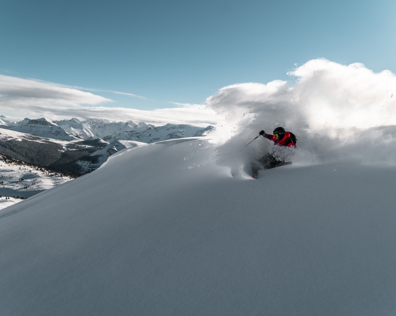 Мужчина спускается на лыжах с горы 