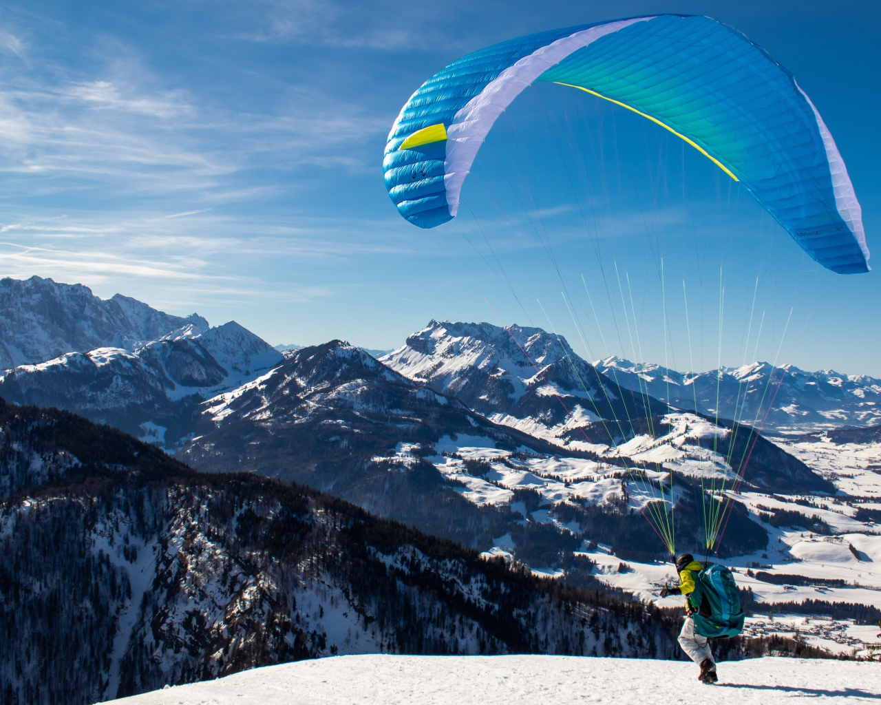 Paraglider jumping from a mountain in winter