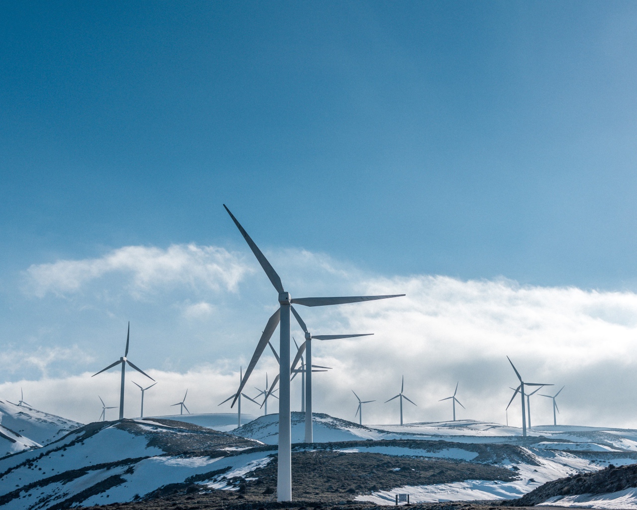Large wind turbines on snowy slopes