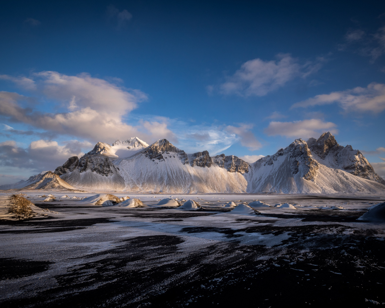 Заледеневшее озеро у заснеженных гор, Исландия