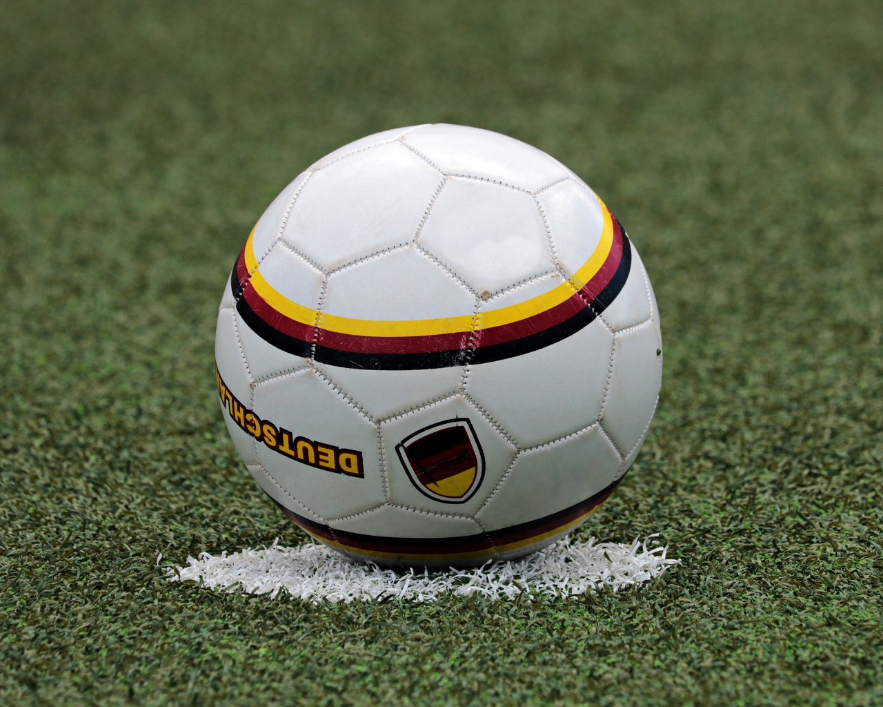 Футбольный мяч лежит на метке на поле 