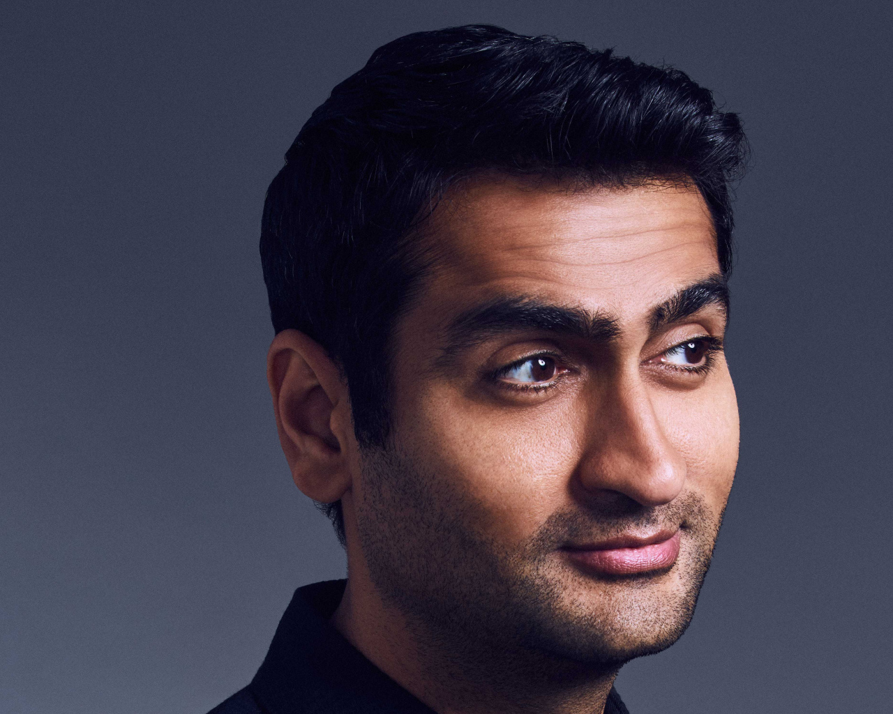 Актер Кумэйл Нанджиани на сером фоне