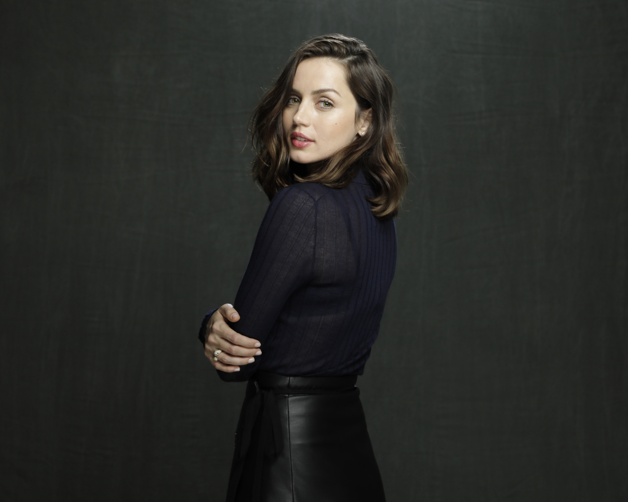 Актриса Ана де Армас в черной юбке на сером фоне