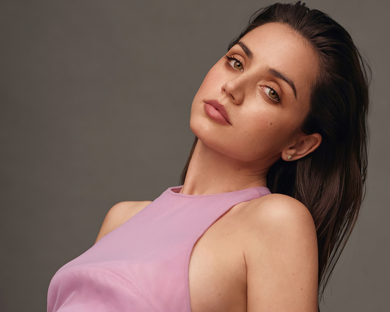 Актриса Ана де Армас на сером фоне в розовой кофте