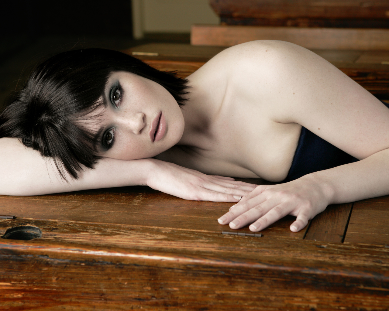 Актриса Джемма Артертон лежит на деревянном столе