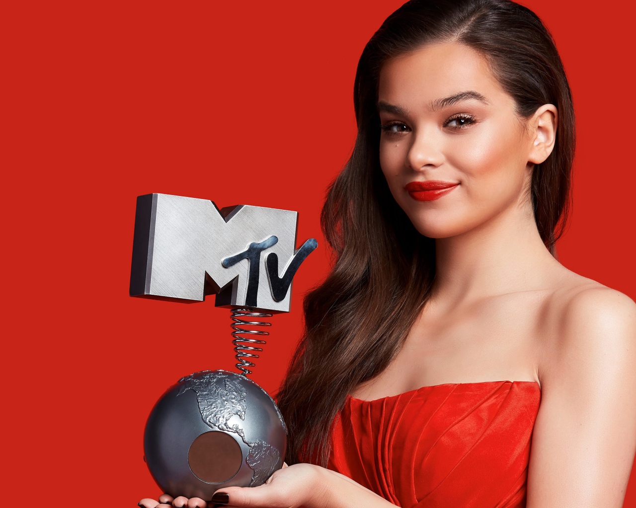 Актриса Хейли Стейнфилд с наградой МТВ на красном фоне