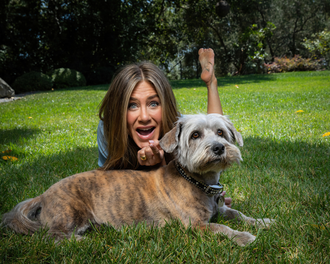 Актриса Дженнифер Энистон с собакой лежит на траве