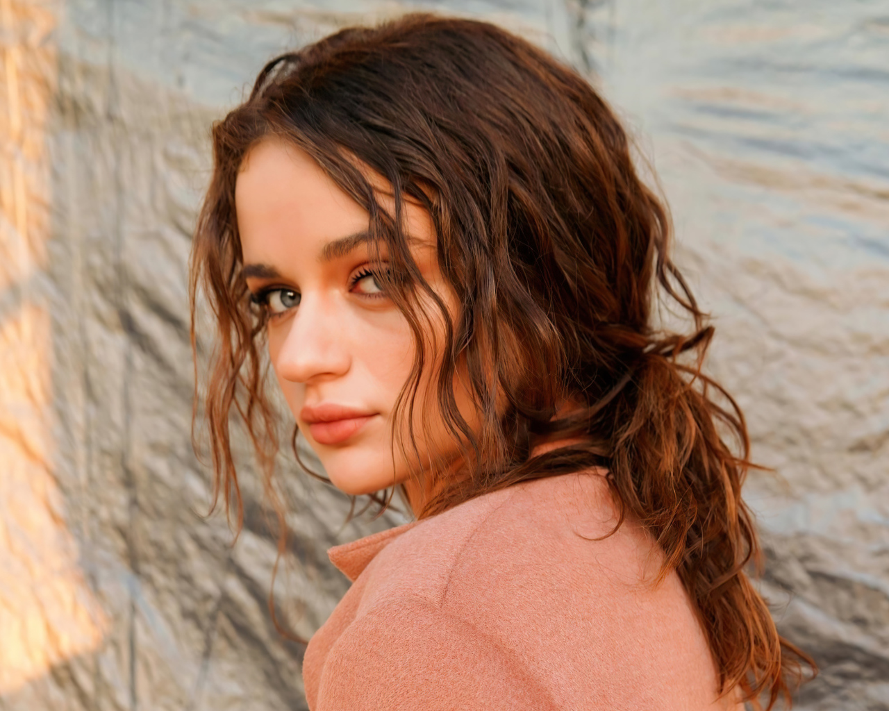 Актриса Джои Кинг стоит боком у стены 