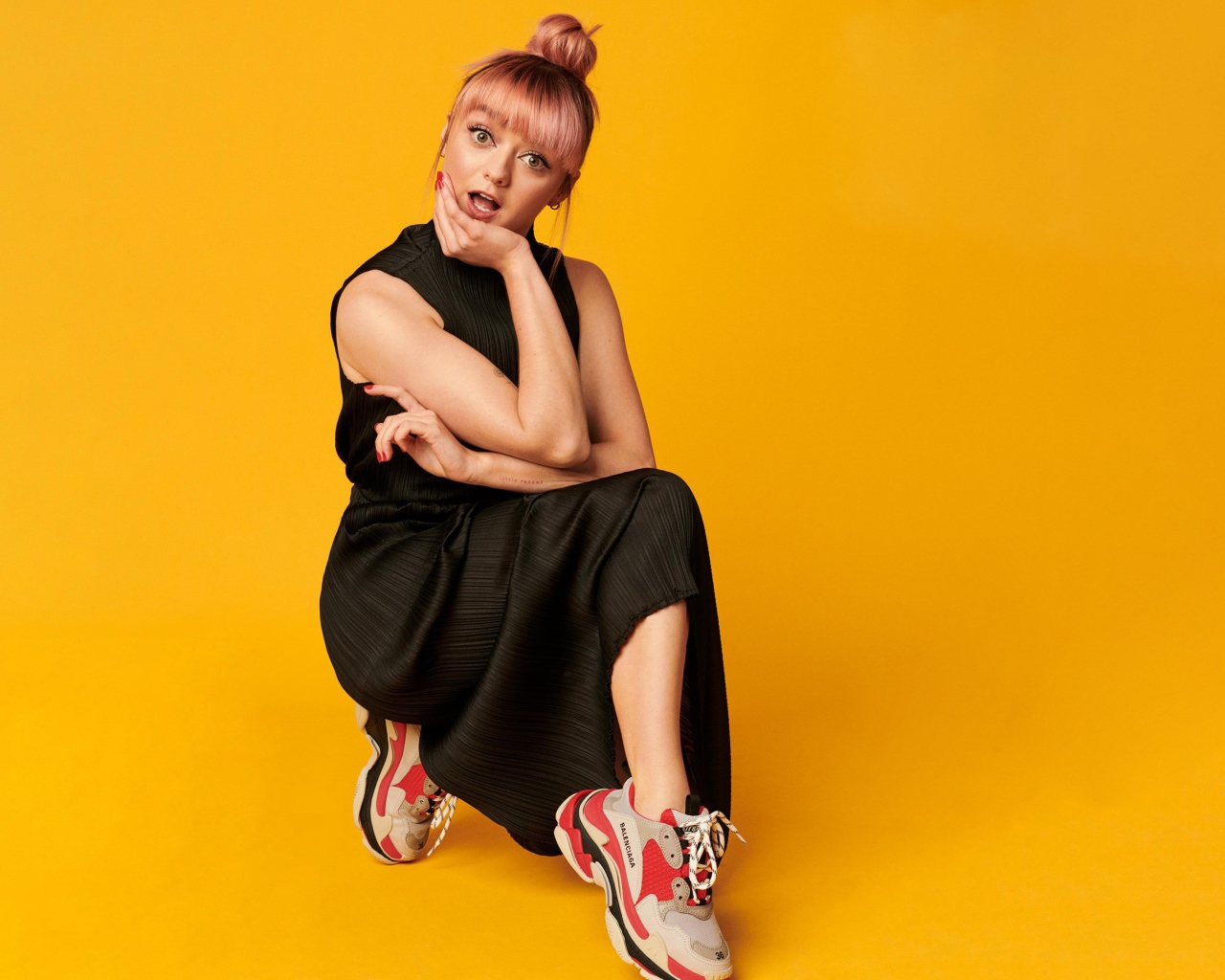 Актриса Мэйси Уильямс в черном платье на желтом фоне