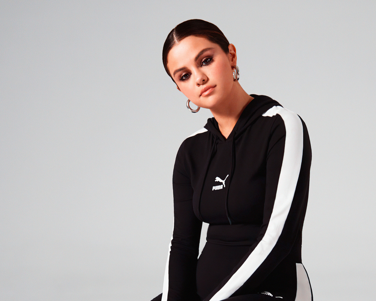 Актриса, модель Селена Гомес в спортивном костюме на сером фоне