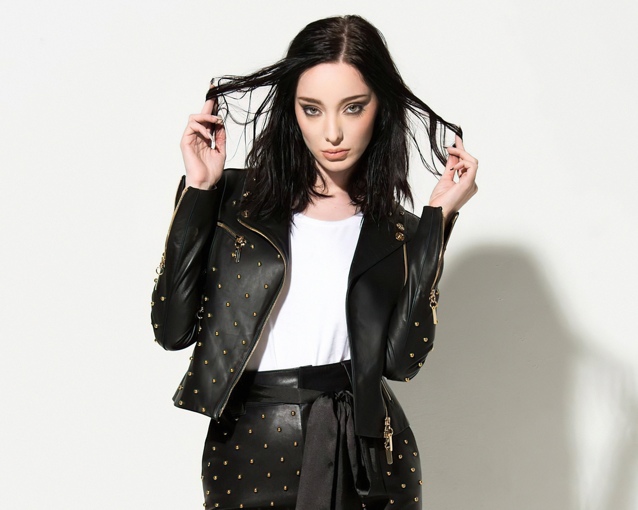 Американская актриса Эмма Дюмон в черном кожаном костюме на белом фоне