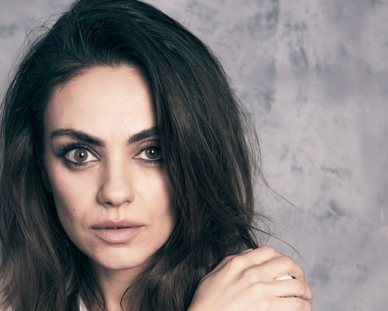 Американская актриса Мила Кунис на сером фоне