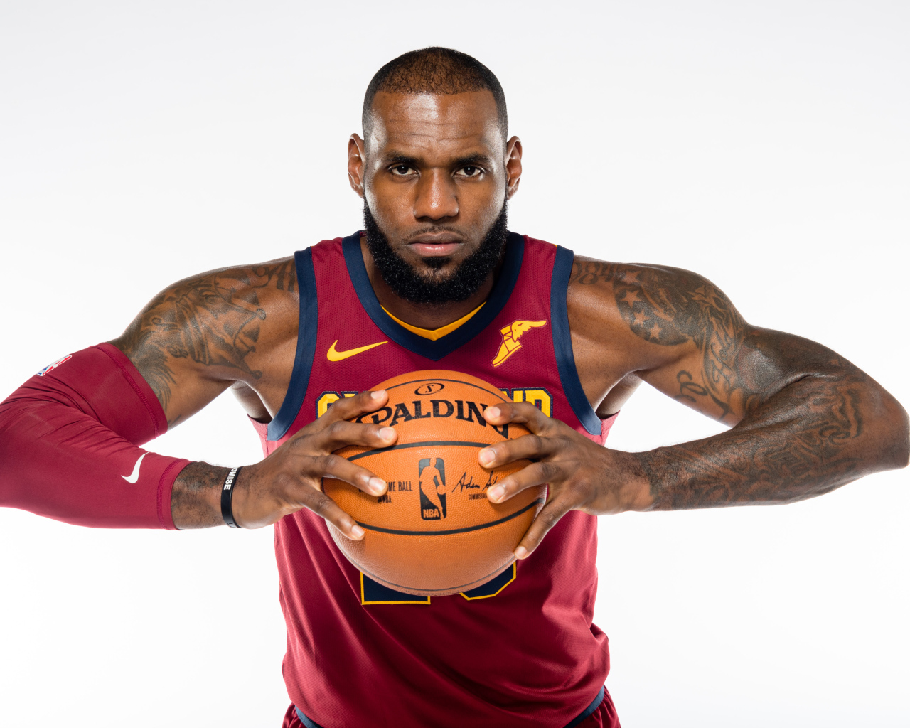 Баскетболист Леброн Джеймс с мячом в руках на сером фоне