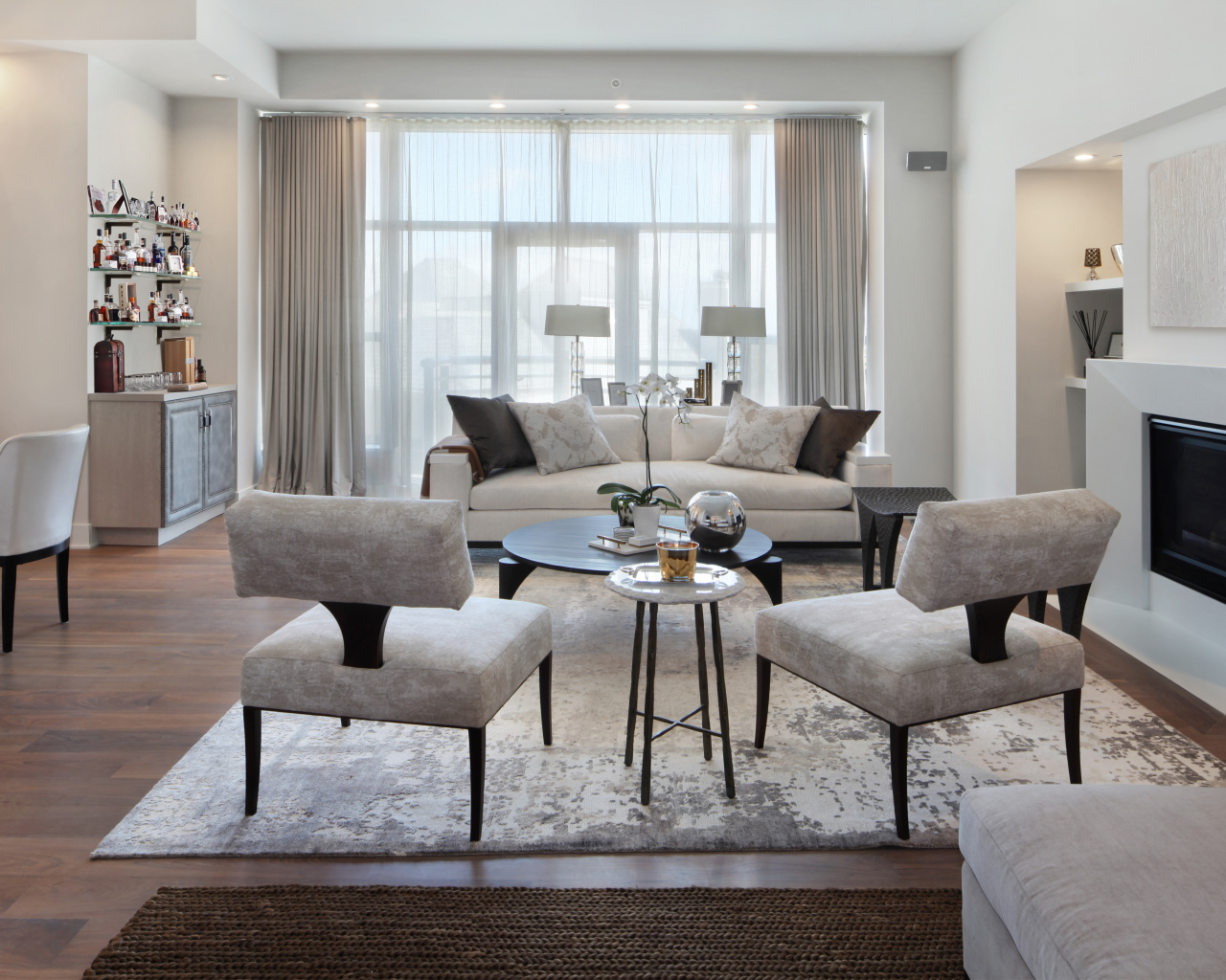 Красивая светлая гостиная с камином и большим окном