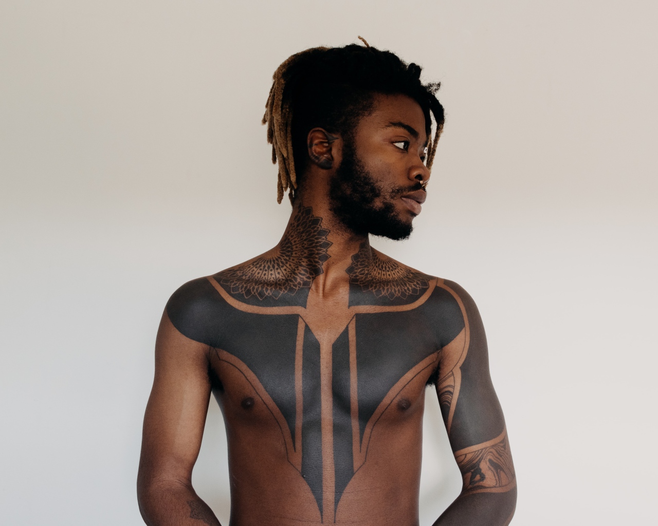 Темнокожий мужчина с татуировками на теле