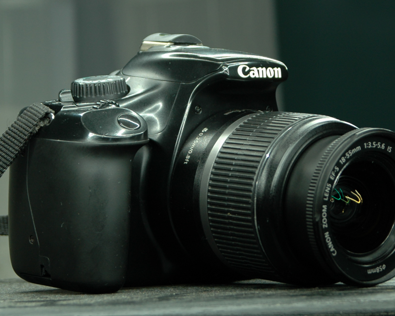 Фотоаппарат Canon 1100D лежит на столе