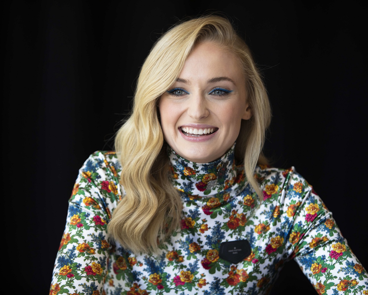 Очаровательная Софи Тёрнер улыбается на черном фоне