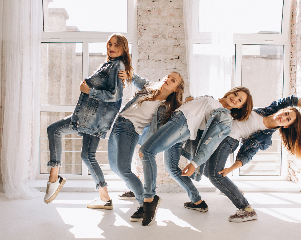 Четыре девушки в джинсовых костюмах занимаются танцами