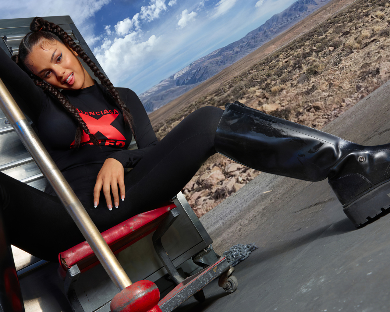 Смешная девушка, певица и актриса Селена Гомес сидит на стуле