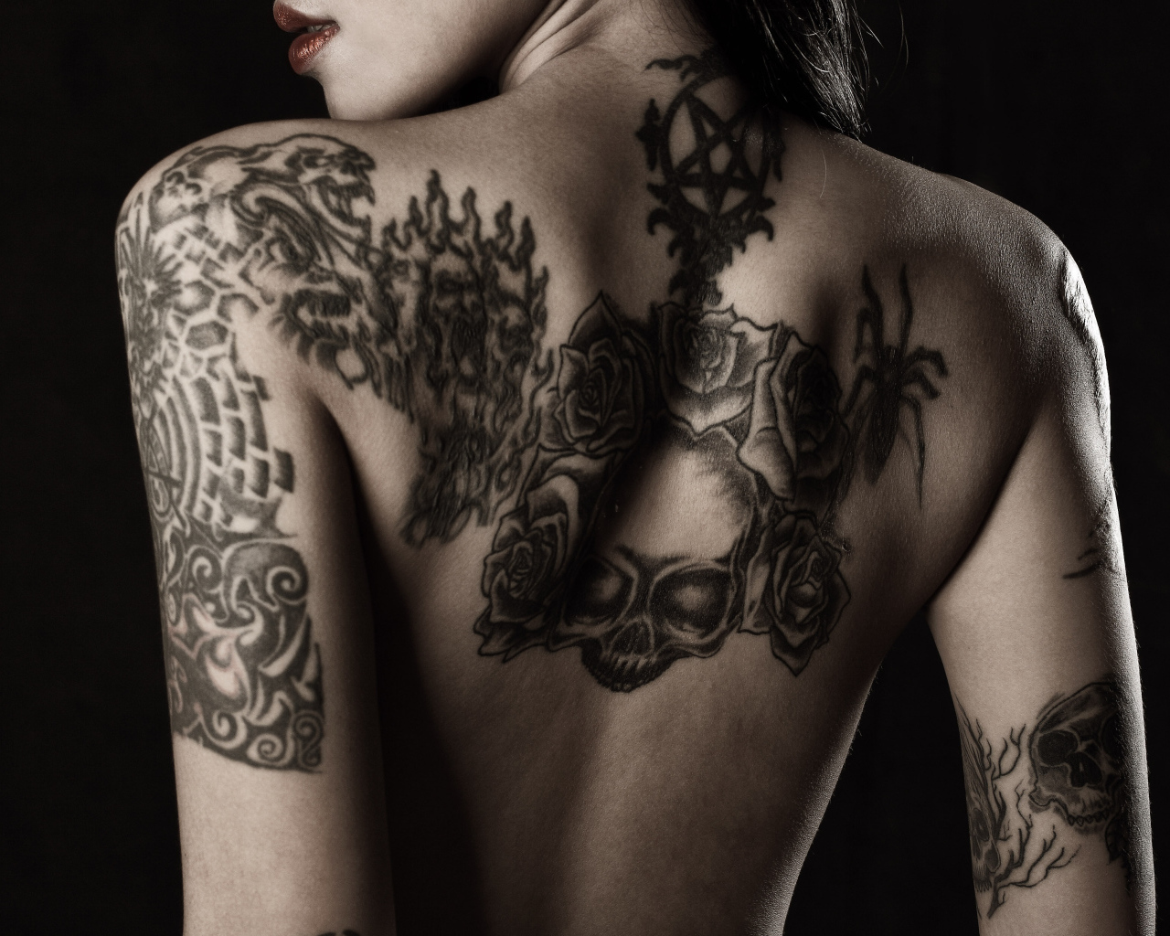 Девушка с татуировками на руках и спине