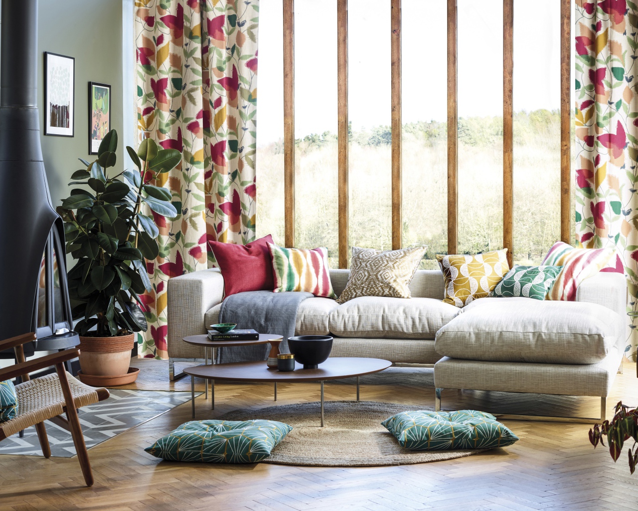 Серый мягкий диван стоит у большого окна в комнате