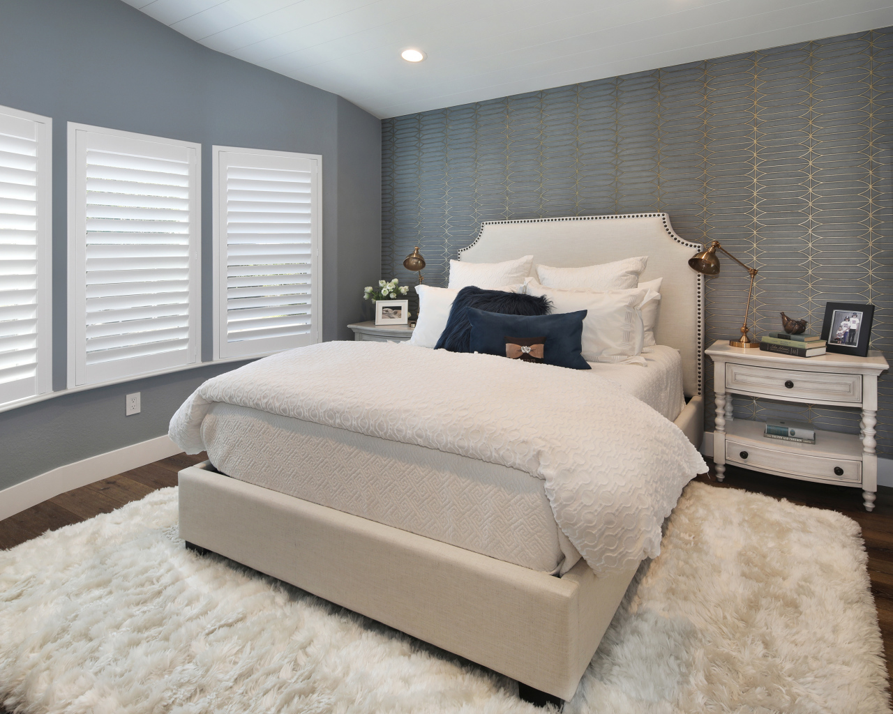 Высокая кровать в спальной комнате в серых тонах