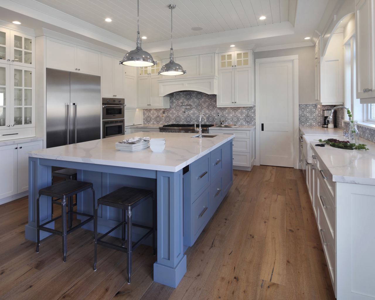 Большой серый стол в просторной белой кухне 