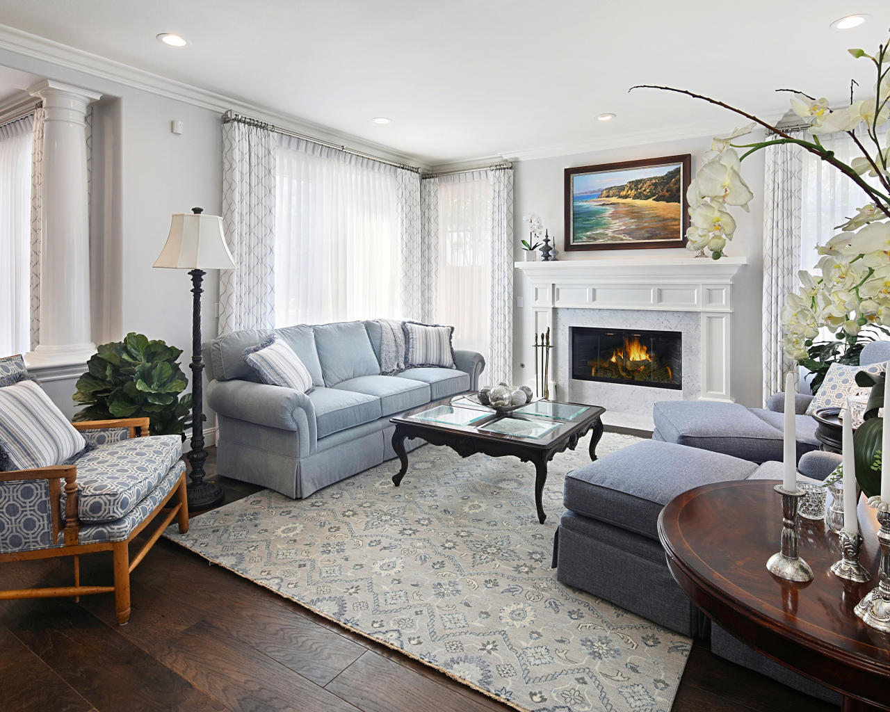 Большая гостиная комната с камином и живыми цветами