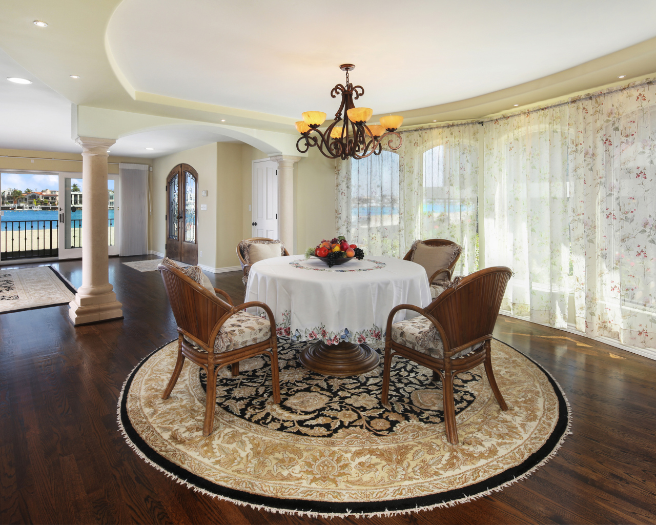 Большая гостиная комната с большими окнами и столом 