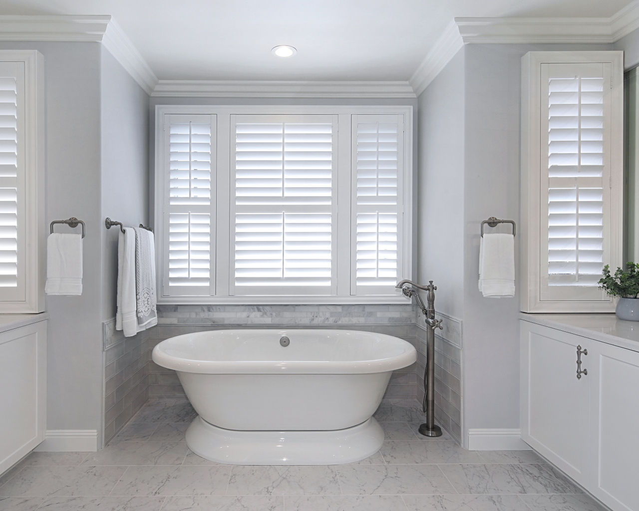 Большая белая ванна в комнате с окнами