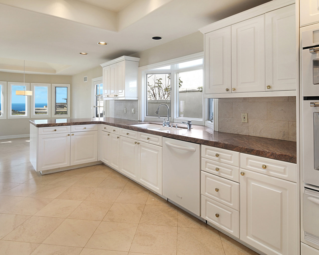 Большая белая кухня с окнами 