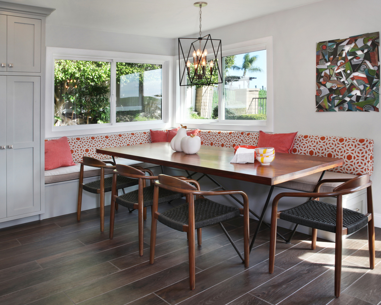 Большой деревянный стол и диван у окна в гостиной 