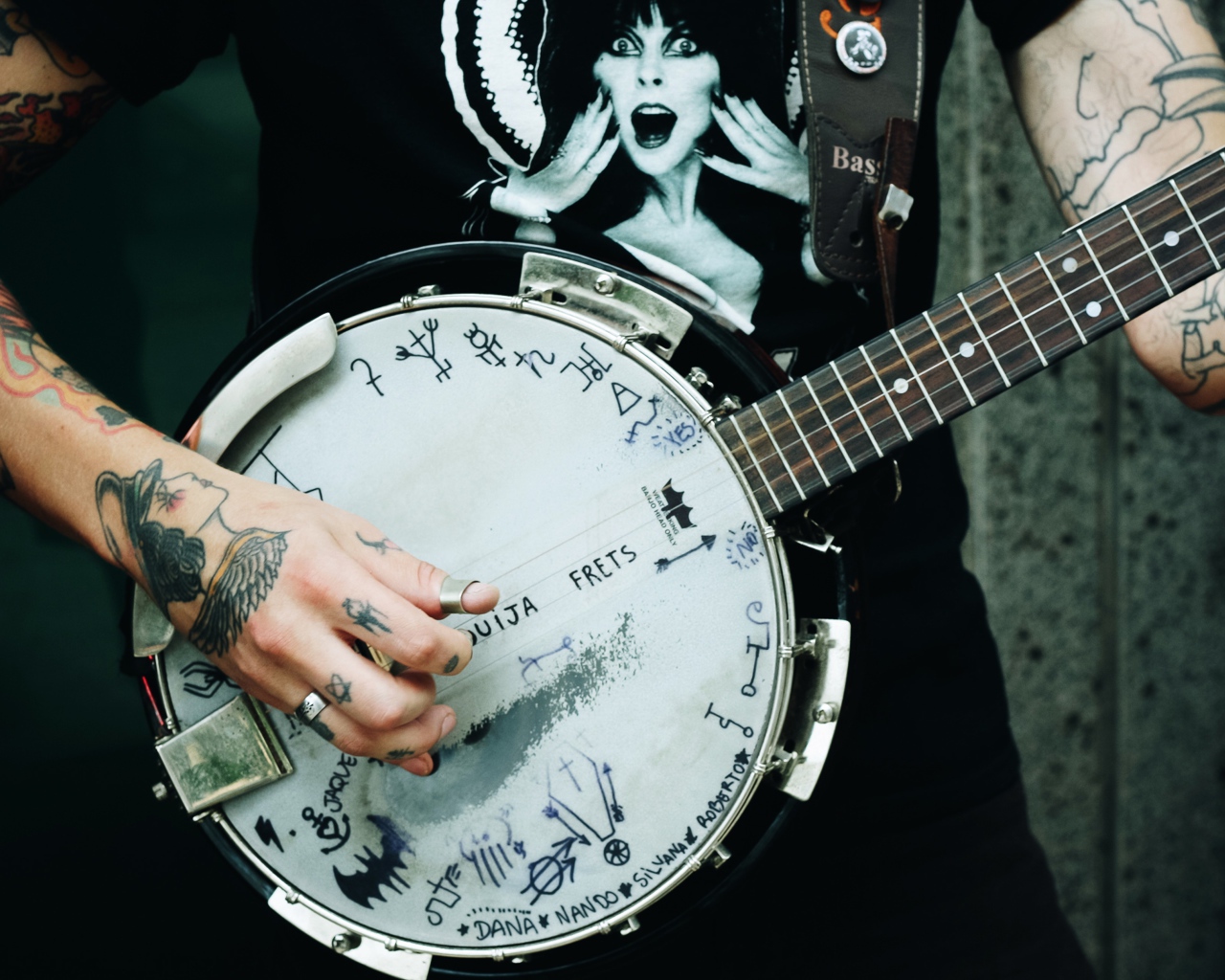 Мужчина с татуировками на руках с гитарой