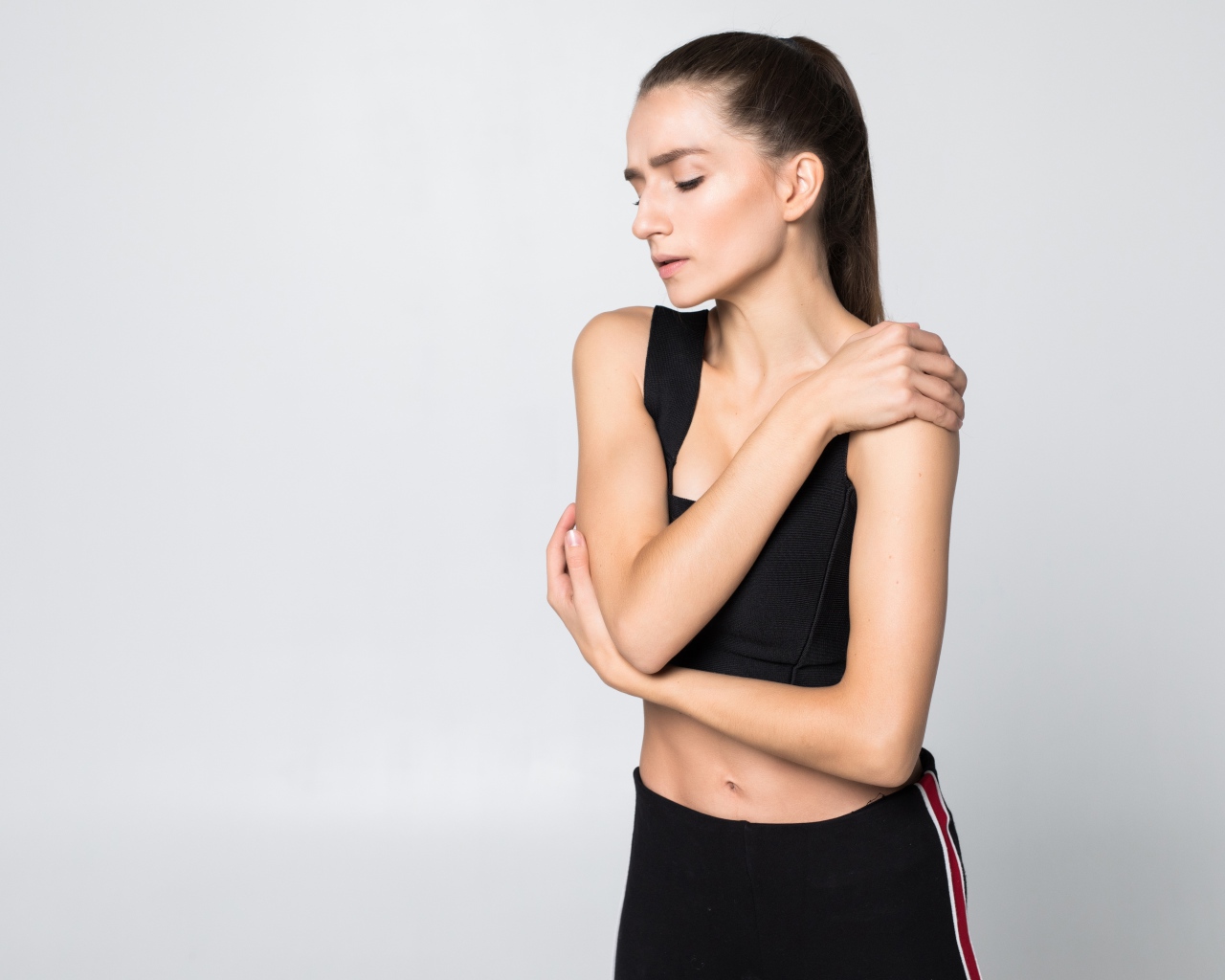 Скромная спортивная девушка на сером фоне