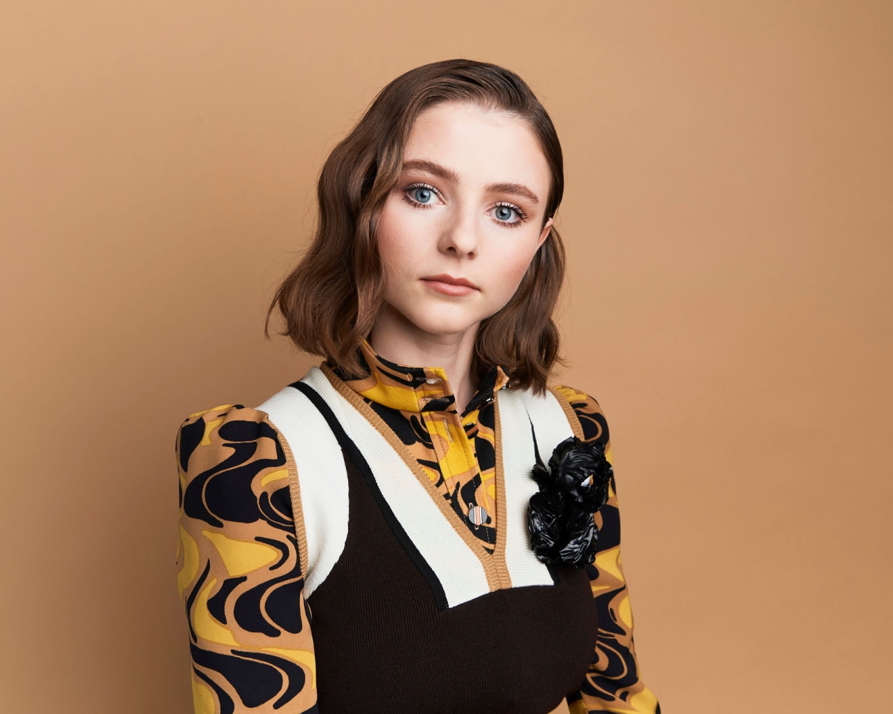 Новозеландская актриса Томасин Маккензи на коричневом фоне