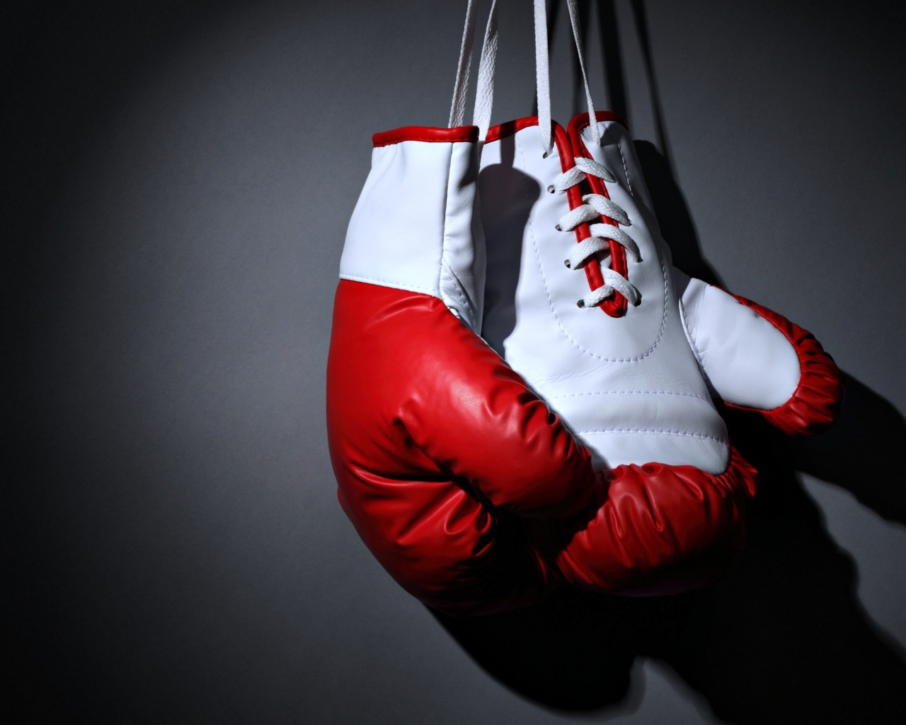 Красные боксерские перчатки на сером фоне