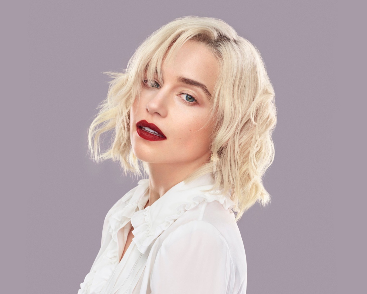 Эффектная блондинка, актриса Эмилия Кларк на сером фоне