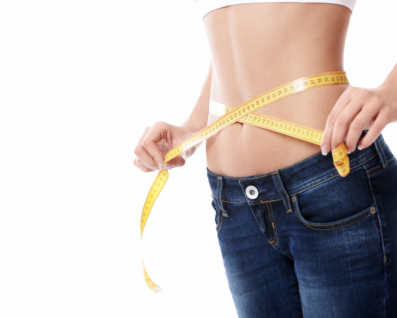Стройная девушка меряет талию сантиметром 