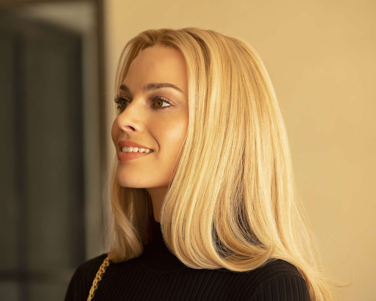 Улыбающаяся блондинка, актриса Марго Робби с карими  глазами